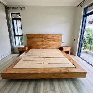 5×6 natural wood platform bed with wide wooden headboard and slatted mattress base in a bright bedroom