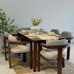 Dark brown rectangular dining table with six grey upholstered armchairs and curved wood-tone frames.