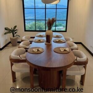 Brown oval 6 seater dining table with six cream upholstered chairs and ribbed pedestal base in a dining room