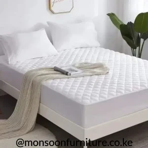 White quilted mattress protector fitted over a mattress with a stitched grid top and plain white side panel.