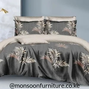 Charcoal botanical duvet with cream and taupe leaf print, light neutral reverse and matching pillowcases arranged on a bed.
