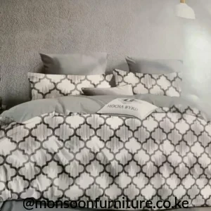 Grey and white trellis-pattern duvet with matching pillowcases arranged on a bed.