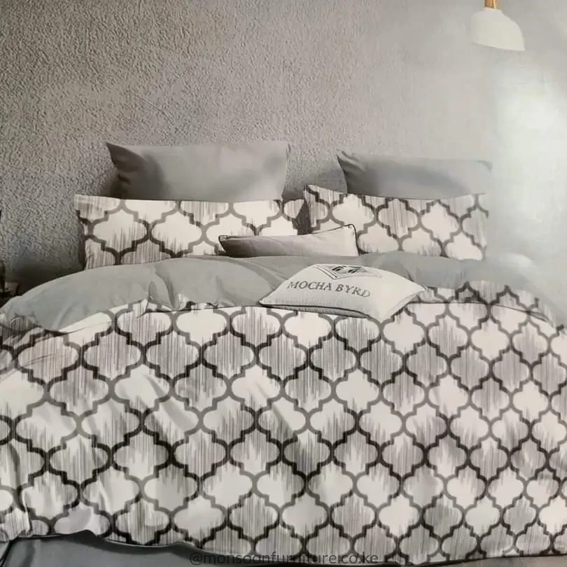 Grey and white trellis-pattern duvet with matching pillowcases arranged on a bed.