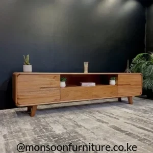 Black and wood-look media cabinet with panelled fronts, recessed handles and raised legs in a living room.