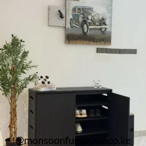Black shoe cabinet with a fluted front, open hinged door, internal shelves and a light cushioned seating section.