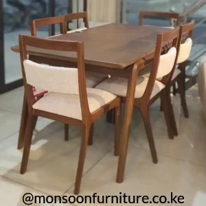 Brown rectangular dining table with six matching chairs featuring cream upholstered seats and back panels.