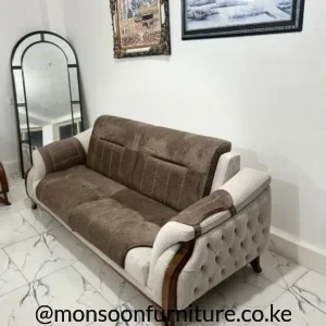 Brown upholstered sofa with cream button-tufted side panels, stitched back sections, brown trim and tapered legs.