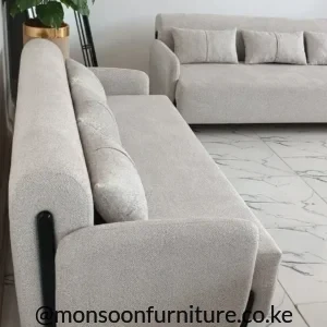 Cream curved bouclé 3 seater sofa with black metal side supports for modern homes in Kenya