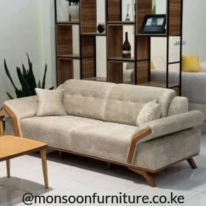 Light cream sofa with padded back sections, rounded arms, warm brown side accents and raised angled legs.