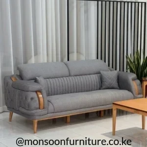 Grey textured sofa with channel-stitched back, button-tufted arms, warm brown accents and raised tapered legs.