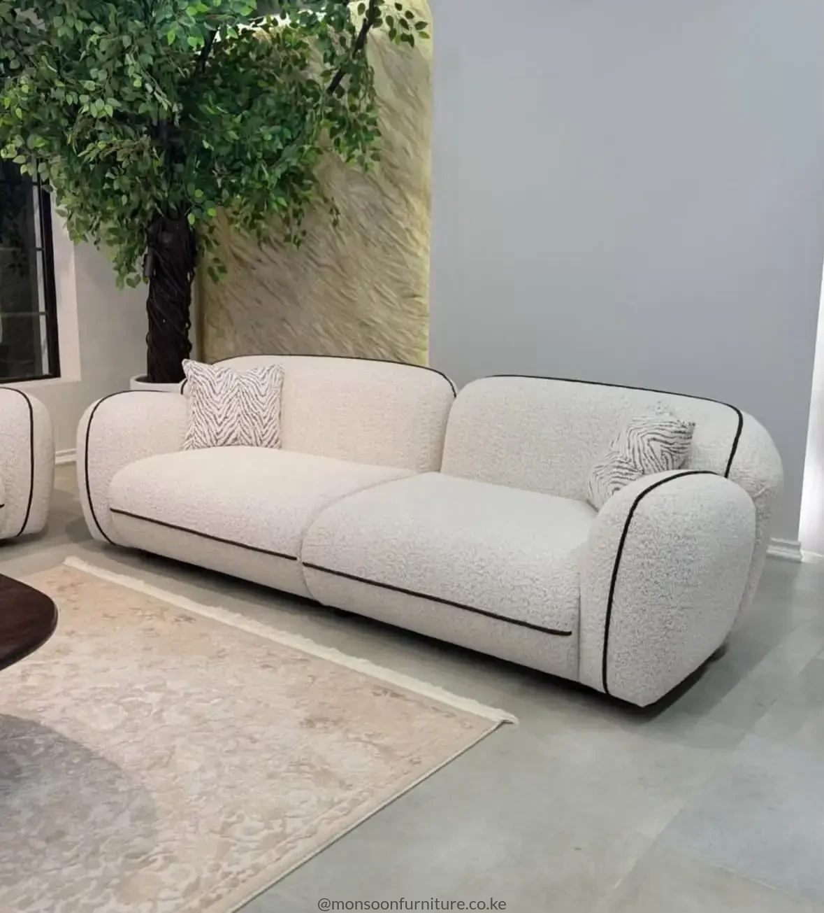 Ivory bouclé 3 seater curved sofa with black piping for modern luxury living rooms