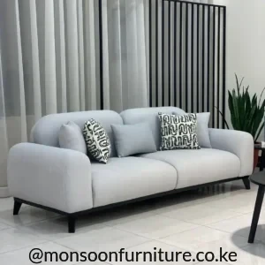 Light grey modern three-seater sofa with rounded arms and black legs for contemporary homes in Kenya