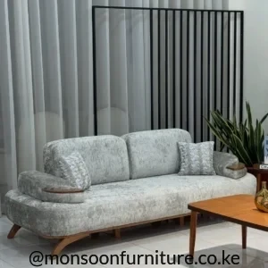 Light grey textured sofa with broad rounded arms, two back cushions, angled brown legs and warm brown arm accents.