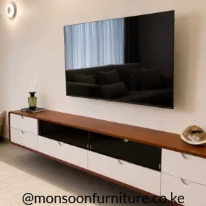 Brown and white floating TV unit with central black open shelves mounted below a wall-hung television in a living room.