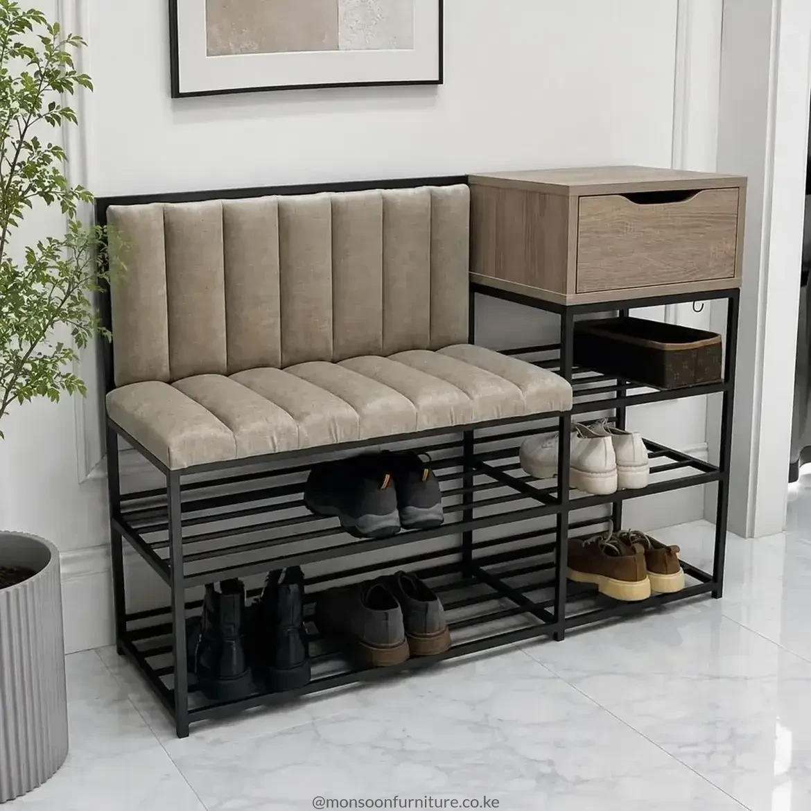 Black-framed entryway bench with beige channelled cushions, open shoe shelves and a wood-look drawer on the right.