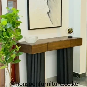 Walnut-look fluted entryway console table Kenya with three handle-free front panels and twin black cylindrical pedestal legs.