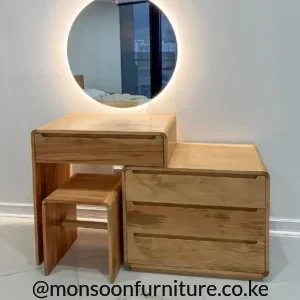 Warm wood-finish dressing table with round illuminated mirror, four drawers and matching stool in a bedroom.