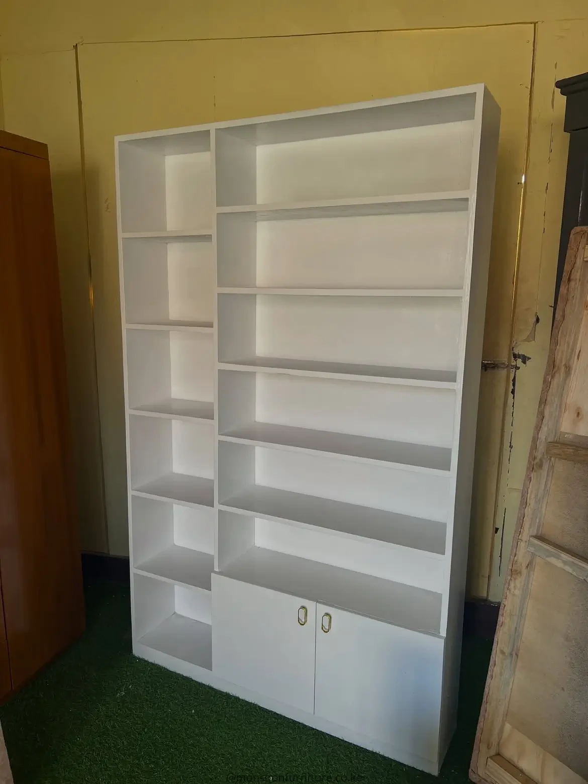 White shoe rack with open shelves and two lower cabinet doors