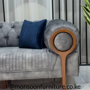 Grey upholstered sofa with rounded wooden arm frame and wooden front leg
