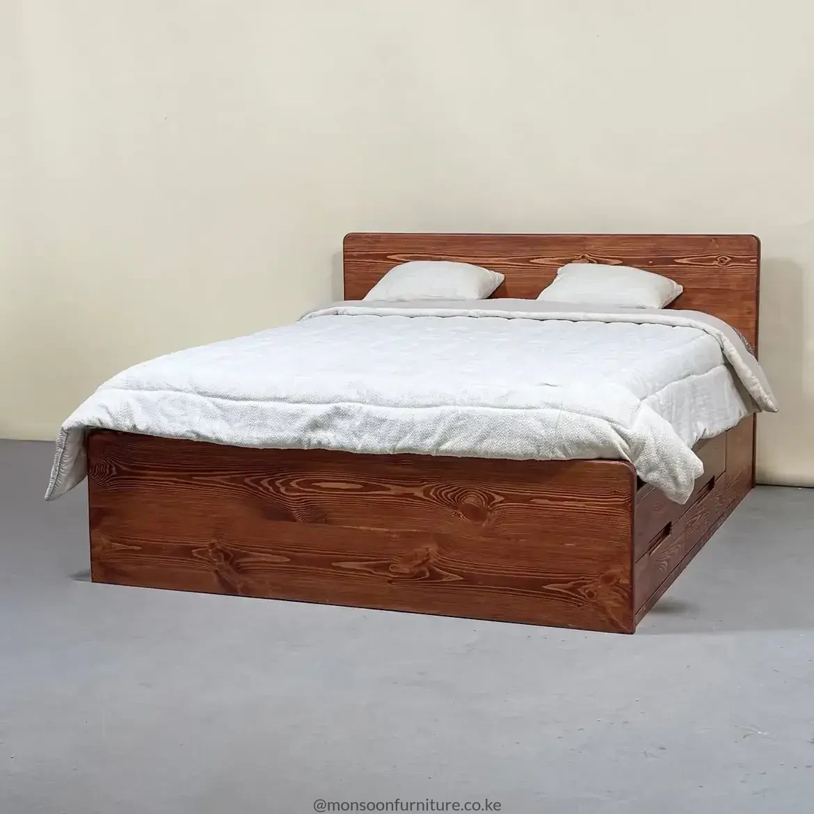 Front view of a warm brown wood-grain bed with rectangular headboard and footboard, dressed in white bedding.
