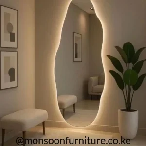 Tall asymmetrical wall mirror with an irregular curved outline and warm perimeter backlighting