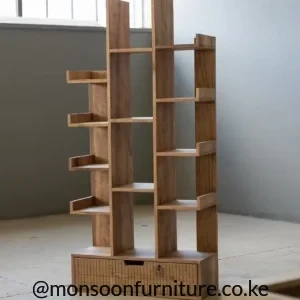 Asymmetrical wood-grain bookshelf with staggered open shelves and one wide drawer at the base