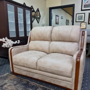 Beige 2 seater sofa with padded back cushions and contrasting brown wooden side accents in Kenya