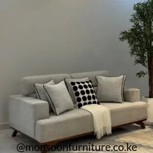 Light beige 3 seater sofa with dark piped cushions, wood-tone base and angled legs in a modern living room