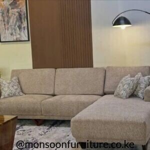 Beige L-shape sofa with chaise, textured upholstery and patterned throw pillows in a living room