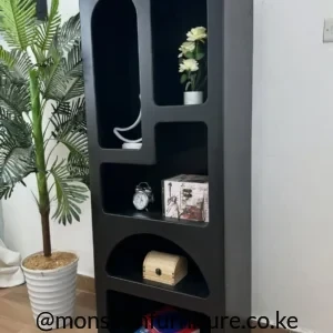 all black bookshelf with five asymmetric open compartments, rounded cut-outs and small gold-tone feet.