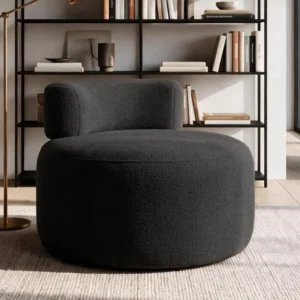 Black rounded accent chair with textured charcoal upholstery, low curved back and armless design