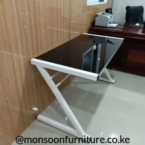 Black study desk with glossy rectangular top and white angular open frame in an office setting