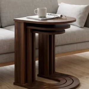 Brown nesting coffee table set with rounded wood-look tops and ribbed supports beside a beige sofa