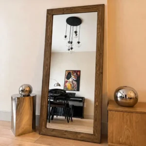 Brown MDF full length rectangular mirror with wood-look frame leaning against a wall