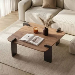 Brown wood-look rectangular coffee table with rounded corners and black corner legs in a neutral living room