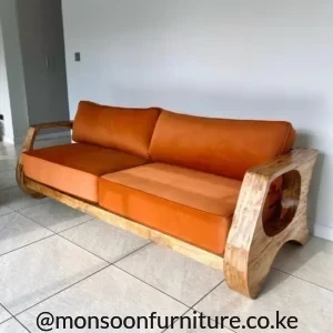 Burnt orange 2 seater sofa with two cushions, exposed wooden frame and large rounded openings in the side arms.