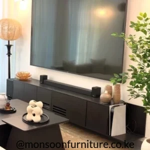Dark floating TV console beneath a wall-mounted television with closed storage and two slotted front sections