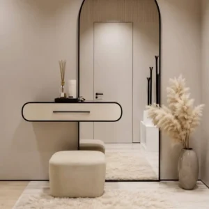 Cream wall-mounted entryway table with tall arched black-frame mirror and beige upholstered pouf