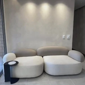 Cream two-piece modular sectional sofa with rounded seats and curved upholstered backrests in a modern living room