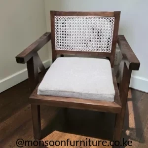 Cream accent chair with dark wood-tone frame, light woven lattice back, broad arms and a pale upholstered seat cushion.