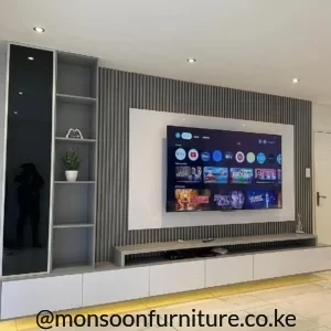 Grey fluted wall panels behind a mounted TV with white surround, display shelving and floating console