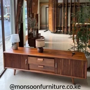 Fluted wooden media console with two drawers and slatted side doors in a bright interior