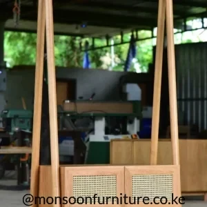 Freestanding wood-tone clothes rack with top hanging rail and two-door woven-front storage cabinet.