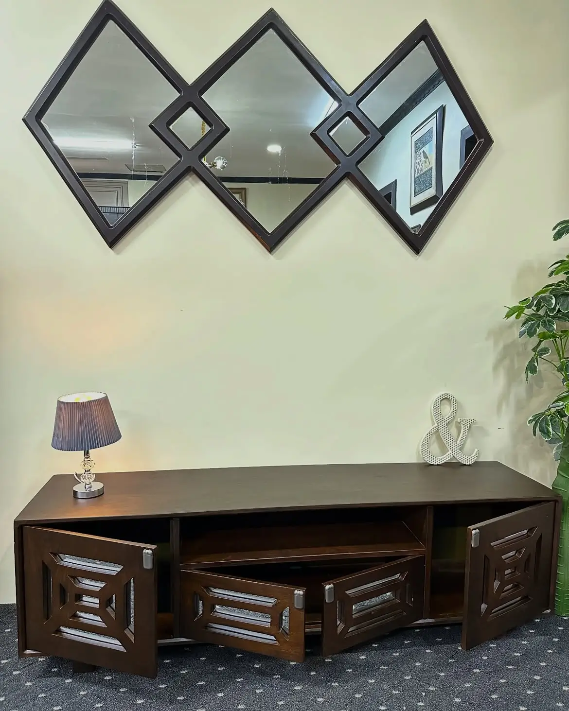 Dark brown geometric TV console with four patterned storage doors and open centre media shelves