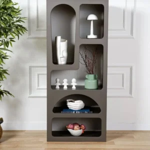 Dark grey geometric display shelf with arched and rectangular open compartments holding decorative ornaments