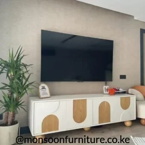 Warm white TV console with wood-tone geometric arch fronts and rounded ball feet in a modern living room