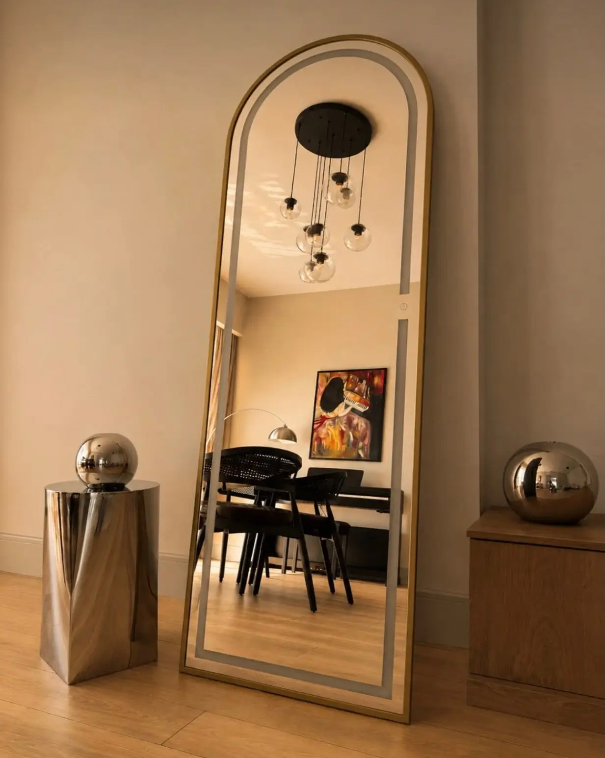 Gold arched full-length floor mirror with slim frame displayed against a neutral wall