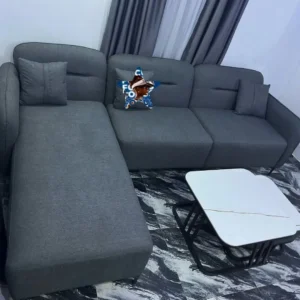 Grey L-shaped sectional couch with chaise-style extension and cushions