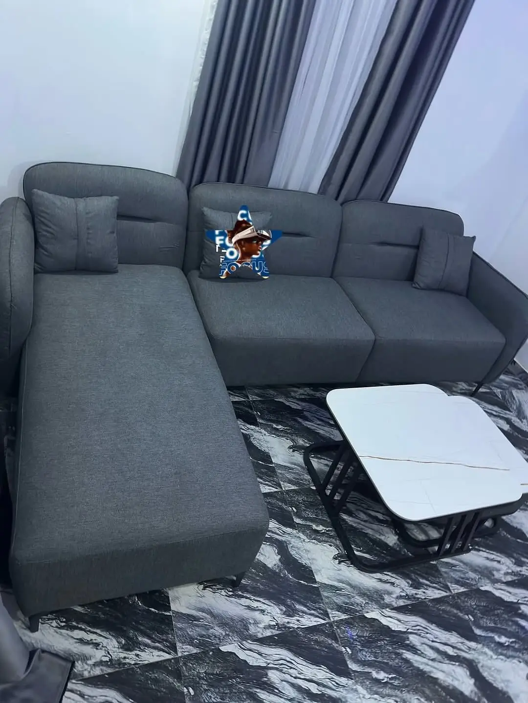 Grey L-shaped sectional couch with chaise-style extension and cushions