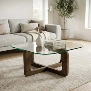 Light wood frame coffee table with clear rounded-square glass top in a neutral modern living room